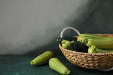 Wicker basket with fresh zucchini on grunge background