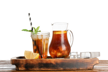 Jug and glass of ice tea with lemon on wooden table against white background