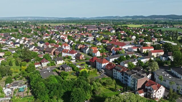 Drone shot of a neighbourhood in Minden town , a middle-sized town in the very north-east of North Rhine-Westphalia, Germany, . Flying over houses and trees .
