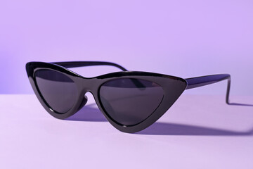 Stylish sunglasses on lilac background