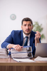 Young male employee and too much work in the office