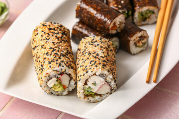 Plate with delicious sushi rolls on table, closeup