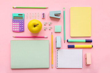Fresh apple with calculator and different stationery on pink background