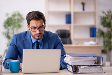 Young male employee and too much work in the office