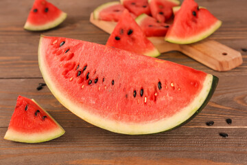 Pieces of fresh watermelon and seeds on wooden table