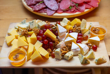 Cheese platter with salami, grapes, walnuts and honey
