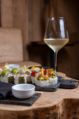 Tablas de sushi acompañado con vino blanco