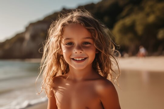 Portrait of a smiling little girl on the beach at sunset.