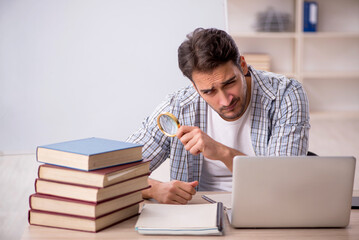 Young male student preparing for exams in the classroom