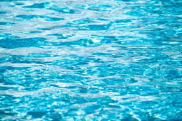 Background of blue water in swimming pool with sun reflection, ripple water wave in pool. Clear water background.