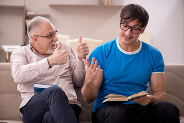 Young male student and his grandfather at home