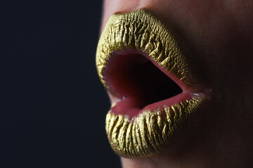 Woman plump lips with gold. Golden glitter lipstick. Shine style for sexy lip. Sensual woman lips. Luxury golden mouth. Glamour gold lips. Golden lips with golden paint or metallic lipstick.