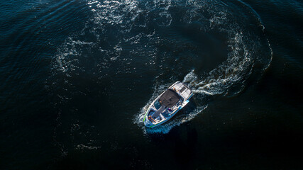 Aerial top view of a wake boat navigating the open river 