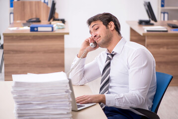 Young male employee unhappy with excessive work in the office