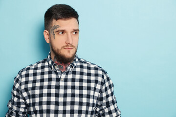Handsome hipster man on light blue background. Space for text
