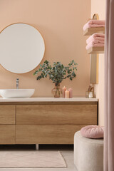 Fototapeta na wymiar Stylish mirror, eucalyptus branches, vessel sink and bathroom vanity. Interior design