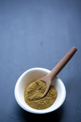 Orégano en polvo presentado en plato de porcelana con cuchara de madera y espacio para texto superior