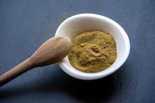 Or&eacute;gano en polvo presentado en plato con cuchara de madera a un lado