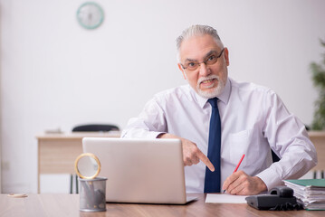 Old male employee working in the office