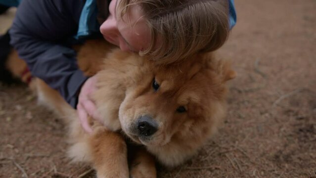Young Man Hugging His Dog On The Ground