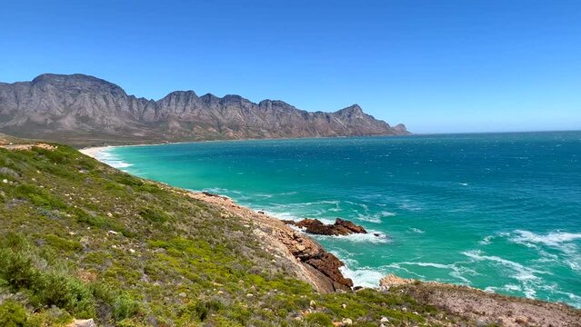Koeel Bay Dappat Se Gat cinematic windy surf waves crashing stunning Kogel Bay Beach Cape Town South Africa coastline aqua deep blue water Gordon's Bay  Garden Route forward pan left