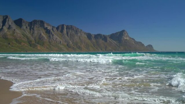 Koeel Bay Dappat Se Gat beach cinematic windy surf waves crashing stunning Kogel Bay Cape Town South Africa coastline aqua deep blue water Gordon's Bay  Garden Route pan right