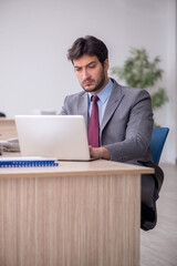 Young male employee sitting in the office