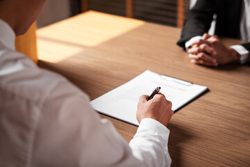 Image of employer or recruiter holding reading a resume during about colloquy his profile of candidate.