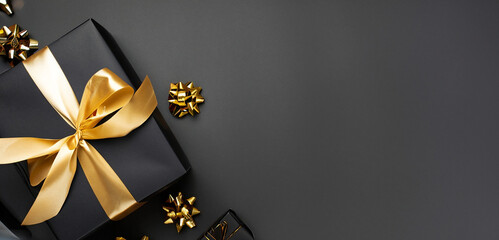 Black gifts with gold ribbons. Christmas gift boxes on black background. Merry Christmas and Happy Holidays greeting card, frame, banner. Black friday. Generative AI