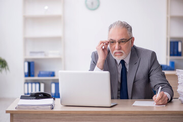 Old male employee working in the office