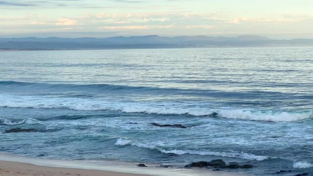 Early sunrise late sunset JBAY Jefferys Bay stunning ocean beach shoreline reef coast Gamtoos Mouth scenic bay mountains in background South Africa WSL Corona Open surfer surf paradise pan right