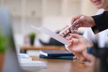 Closeup view of businesspeople checking financial data or marketing report in office.