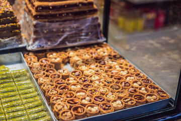 Traditional oriental sweet pastry cookies, nuts, dried fruits, pastilles, marmalade, Turkish desert with sugar, honey and pistachio, in display at a street food market
