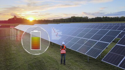 Engineer testing new installed solar panels on farm field at sunset - loading battery Digital motion graphic and holograms - aerial backwards shot - Powered by Adobe