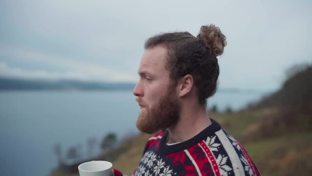 A Guy Is Drinking Coffee In A Mug Outside With Nature Background. Close Up