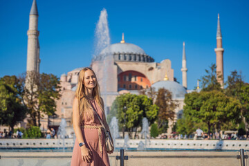 Woman enjoy beautiful view on Hagia Sophia Cathedral, famous islamic Landmark mosque, Travel to Istanbul, Turkey. Sunny day architecture and Hagia Sophia Museum, in Eminonu, istanbul, Turkey. Turkiye