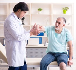 Obraz premium Old man visiting young male doctor