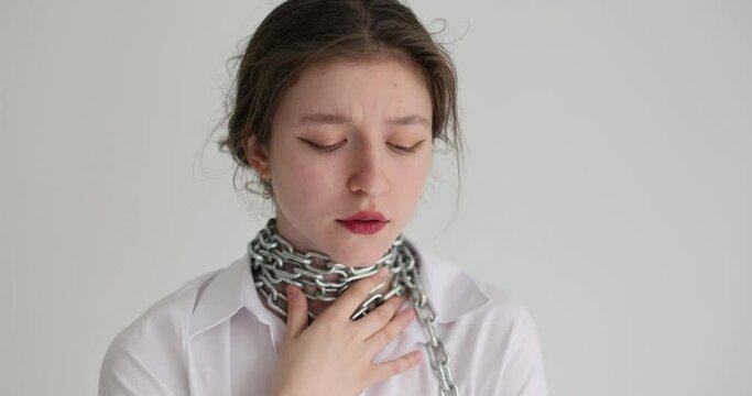 On the neck of a young woman is a steel chain, close-up. Concept for the coercion of women, violence