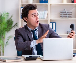 Naklejka premium Young male employee working in the office