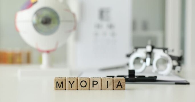 Myopia is an inscription on wooden cubes on a table in a clinic, a close-up. Eye disease, diagnostics