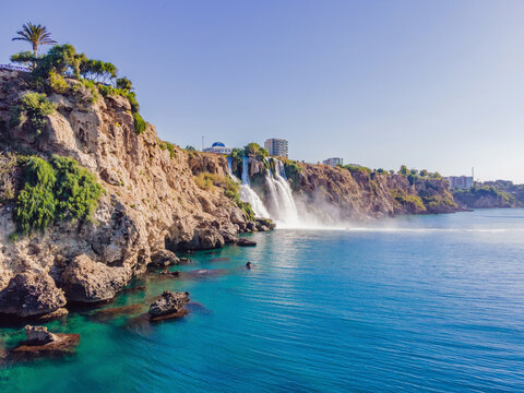 Lower Duden Falls drop off a rocky cliff falling from about 40 m into the Mediterranean Sea in amazing water clouds. Tourism and travel destination photo in Antalya, Turkey. Turkiye.
