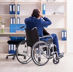 Young male employee in wheelchair working in the office
