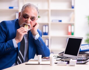 Old face injured employee sitting in the office