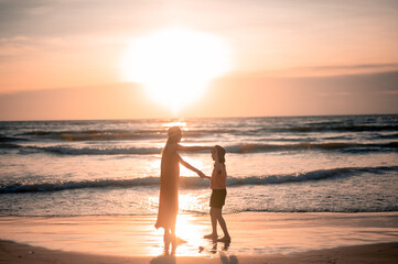 Fototapeta premium child, mother, summer, beach, person, sunset, family, happy, woman, vacation, sea, daughter, together, girl, holiday, lifestyle, fun, little, joy, female, young, childhood, water, outdoor, silhouette,