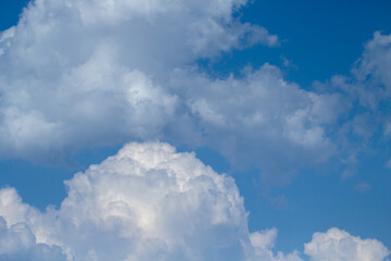 Obraz na płótnie Canvas Blue sky with white puffy fluffy clouds, horizontal natural background