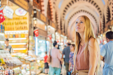 Obraz premium A tourist woman walks among the countless shops at the Grand Bazaar and Egyptian Bazaar in Istanbul. Shopping and travel in Turkey concept. Istanbul historical Egyptian Bazaar. Misir Carsisi, spice