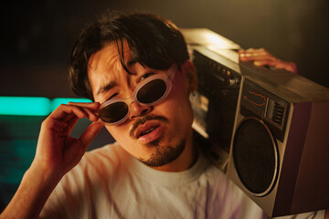 Fashionable Asian man with boombox.