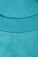 Fragment of a turquoise t-shirt shot close-up.
