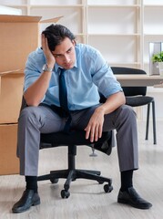 Young man employee with boxes in the office