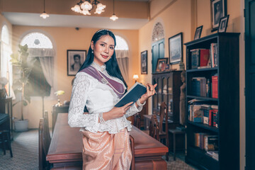 Chiang Mai, Thailand - March 31, 2023: A pretty young Asian woman wearing in Thai dress costume traditional according to Thai culture standing at Library of ancient Thai buildings. Old Fashion Lanna